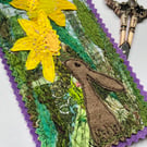 Upcycled embroidered spring rabbit and daffodil home decoration.