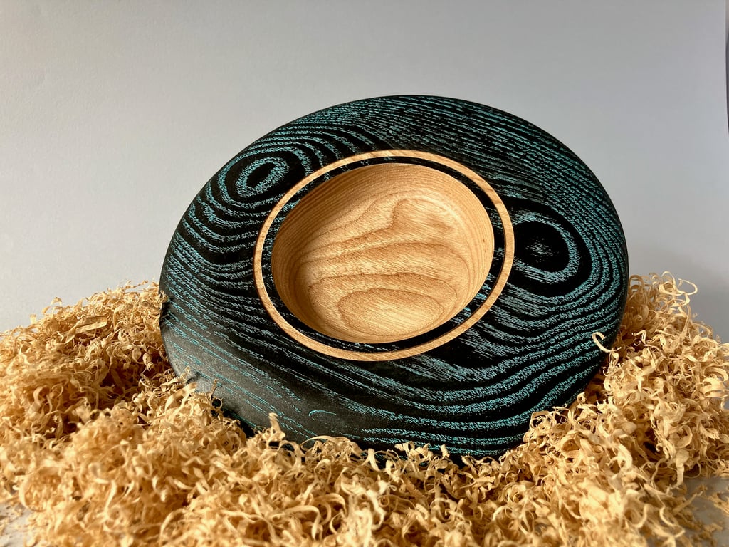 Small hand-turned wooden platter with vibrant aqua grain detail.