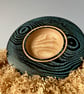 Small hand-turned wooden platter with vibrant aqua grain detail.