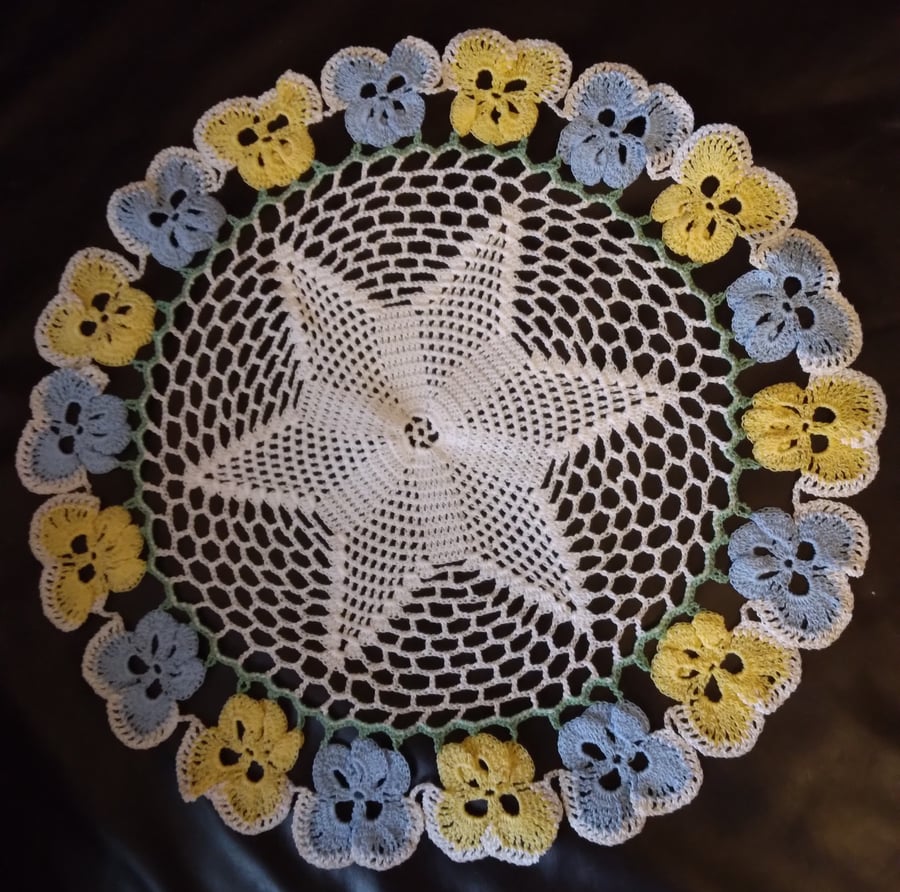 Crochet cotton table mat with blue and yellow pansy border