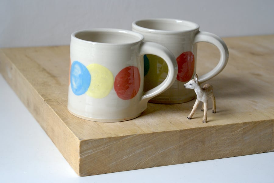One handmade stoneware mug with colourful dots and 'more please' message