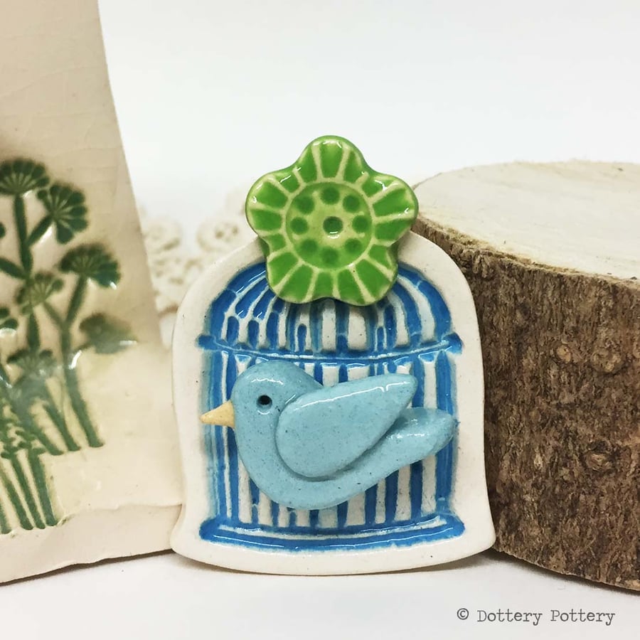 Little ceramic bird cage brooch with flower. Pottery jewellery