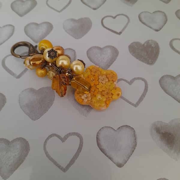 SHADES OF YELLOW AMBER AND ANTIQUE BRONZE FLOWER POLYMER CLAY BAG CHARM.