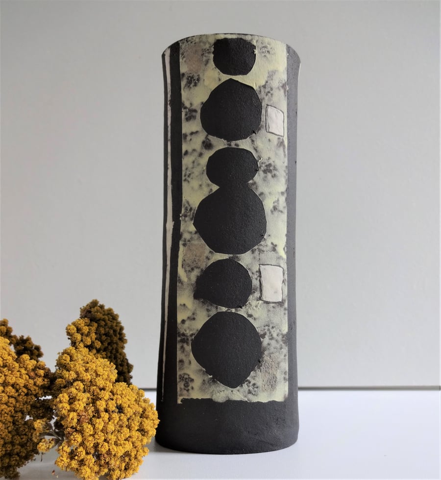 Gloria.  Black ceramic vessel with mid century lemon, grey, white motifs. 