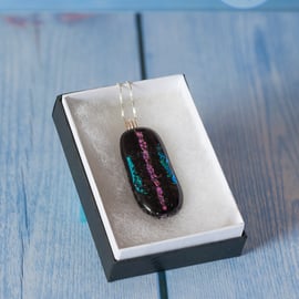 Black fused glass pendant with sparkle stripes in turquoise and pink