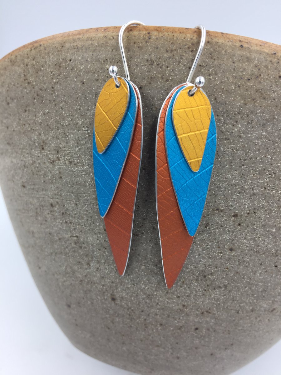 Anodised aluminium 3 layer parrot wing earrings in turquoise orange and gold.