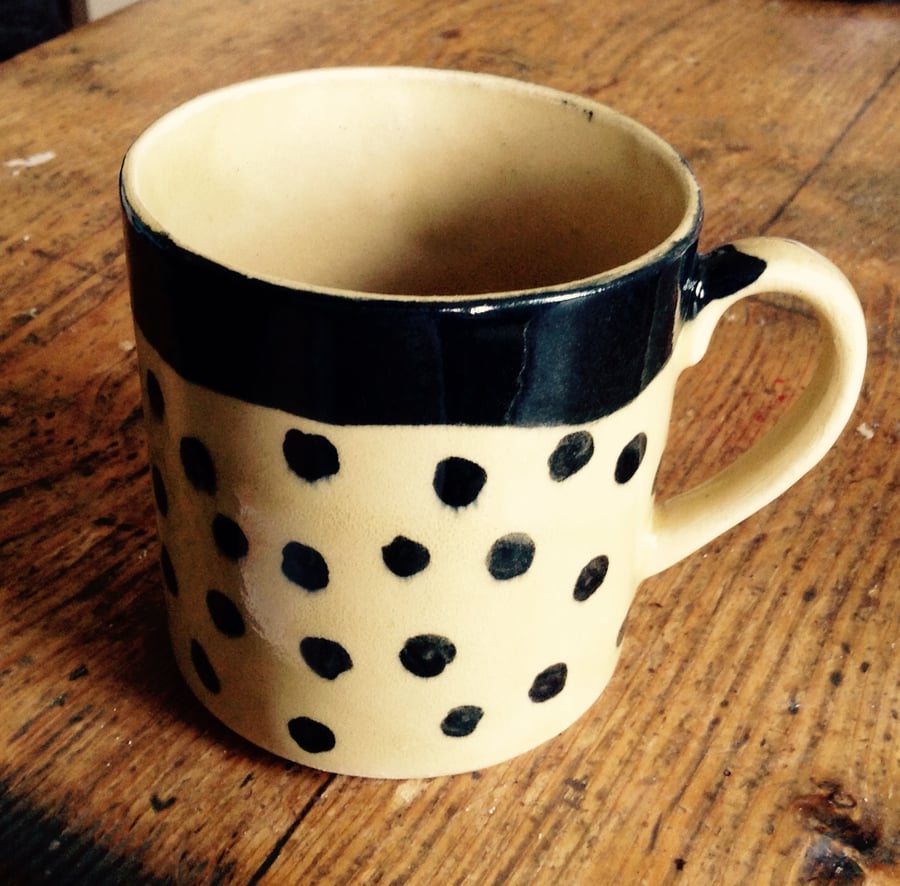 Mug in cream stoneware with brown dots.    