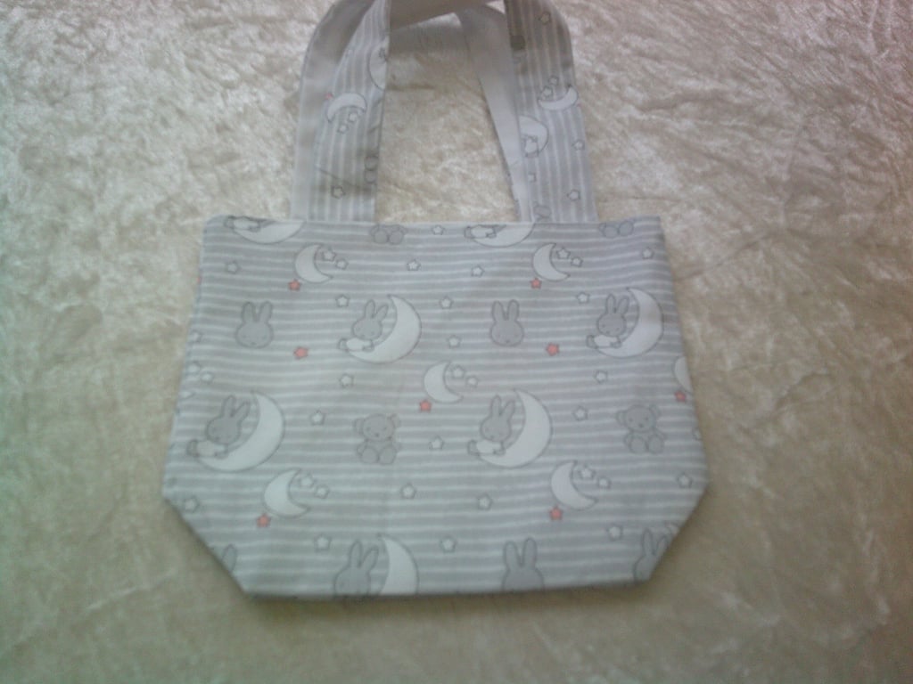 Miffy Rabbit sitting on Crescent Moons on a Pale Grey background Fabric Bag
