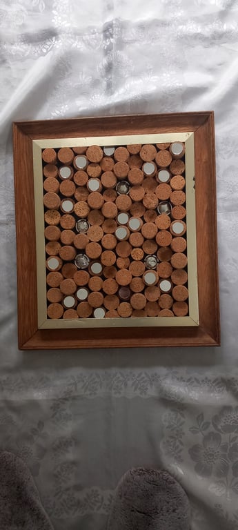 Cork board or framed wall art with champagne corks and mirrors.