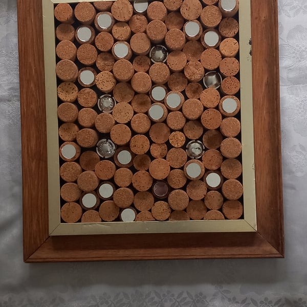 Cork board or framed wall art with champagne corks and mirrors.