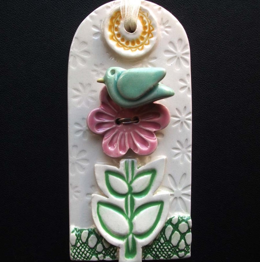 Ceramic tag decoration with bird and flower button