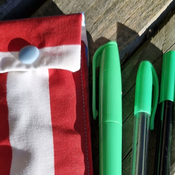 Red white and blue striped  pen case with 4 green pens.