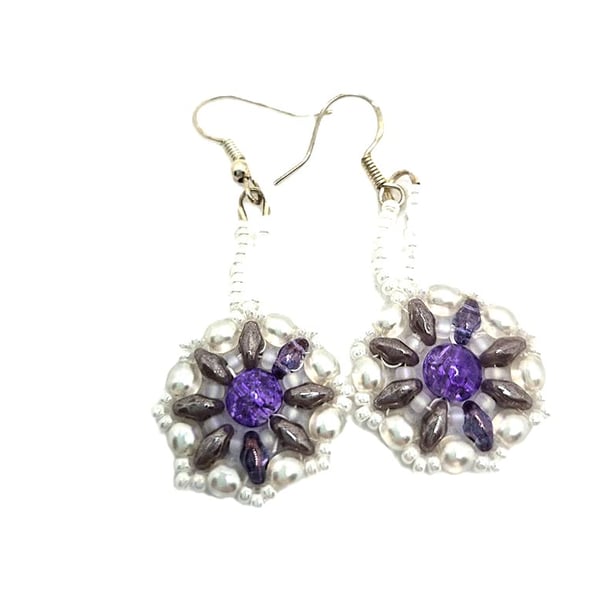 Handmade white beaded earrings with larger purple bead in the centre