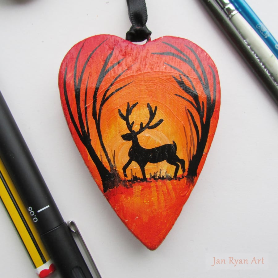 Stag silhouette by an Autumnal sunrise, orange hanging heart