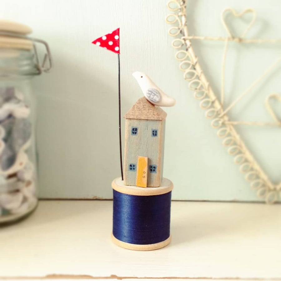 Little sea house with clay seabird on wooden bobbin