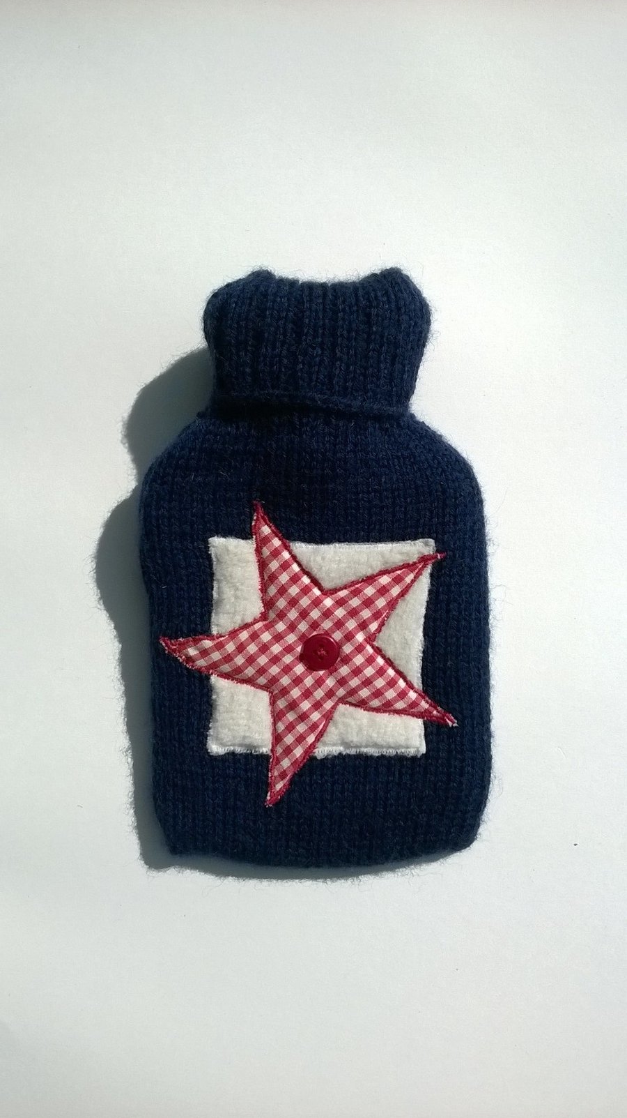 Hand knitted navy hot water bottle with gingham star