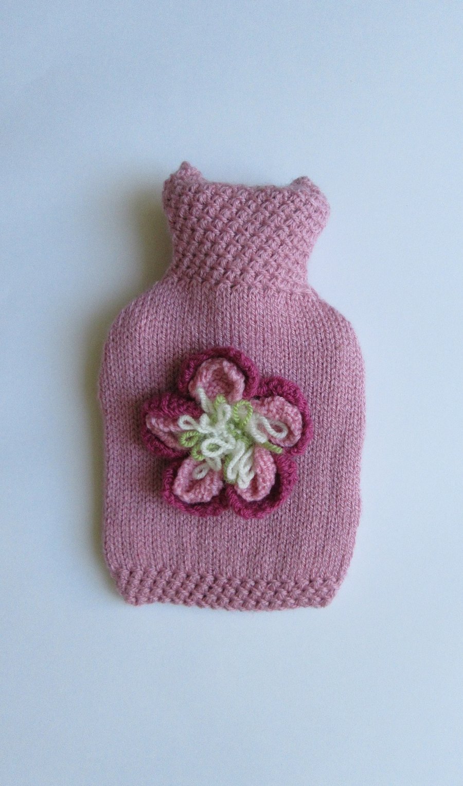 Hand knitted pink peony hot water bottle cover