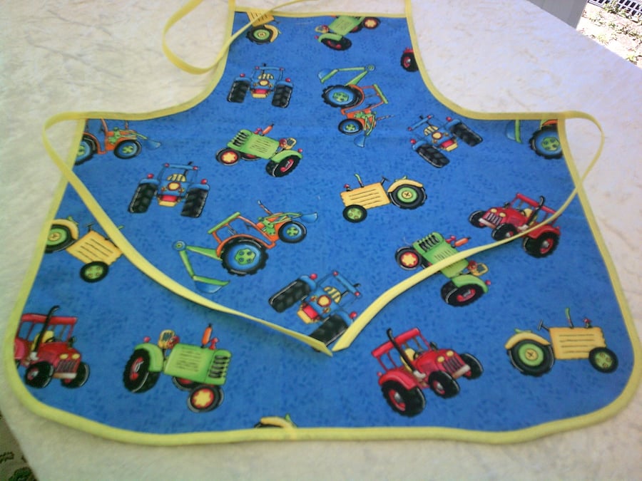 Colourful Tractors on blue background Baby Apron
