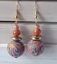 Handmade dangly polymer clay earrings in an orange swirl  design - Image 4