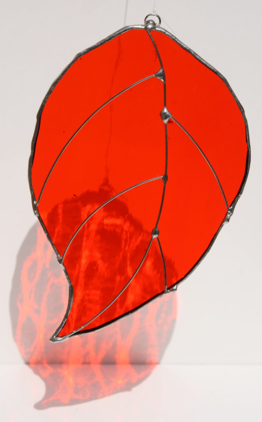 Handmade red stained glass hanging leaf.