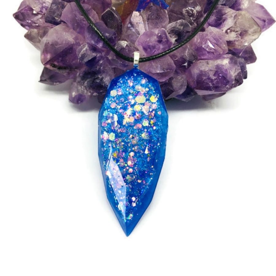Blue teardrop jewel toned statement pendant on a black cord necklace.