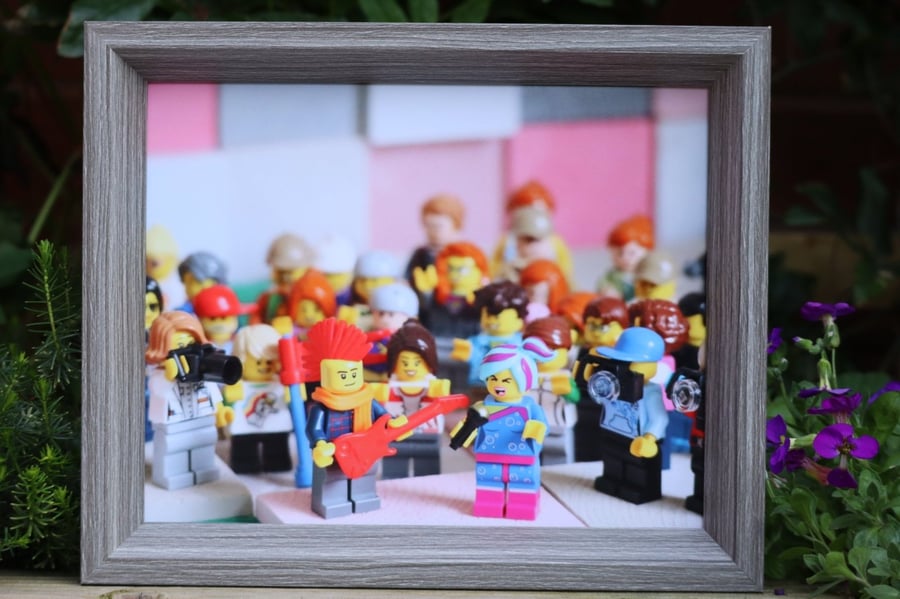 Framed Lego figures, Flashback Lucy sings everything is awesome to her fans.