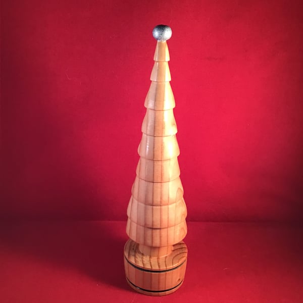 TallChristmas tree  topped with silver orb