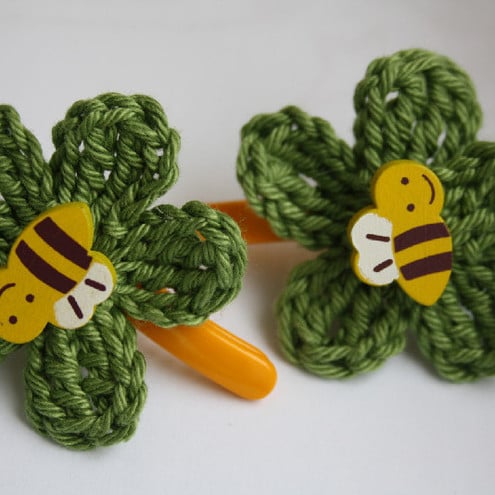 A pair of hair clips with crochet flowers, pastel green, yellow bee