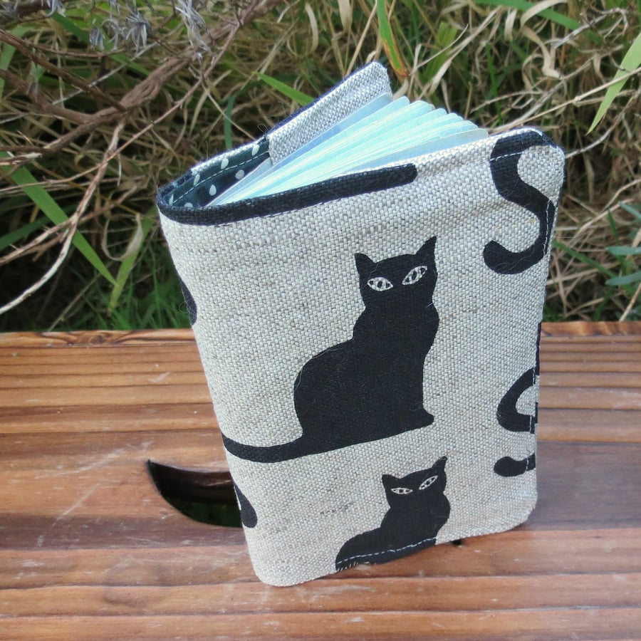 A linen passport sleeve with a whimsical cat design. Passport cover.