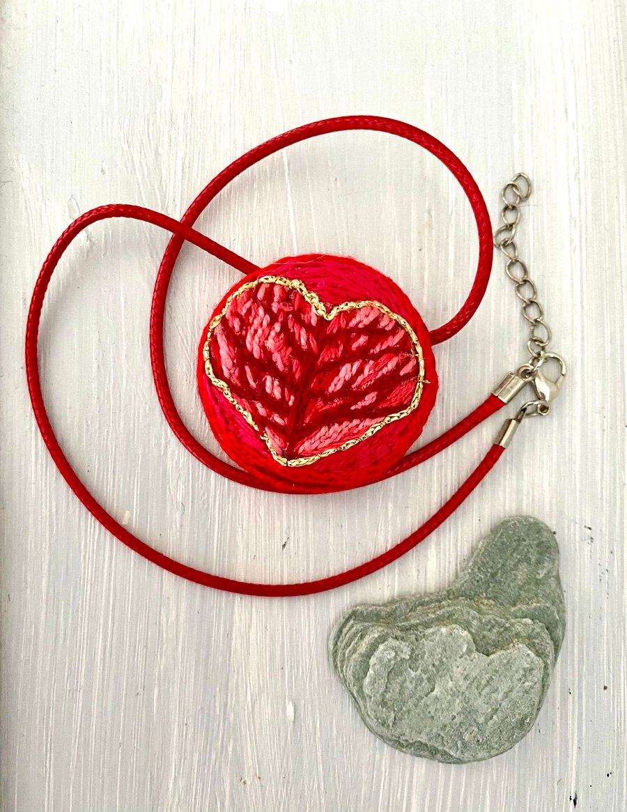 Heart pendant, hand embroidered in shades of red 