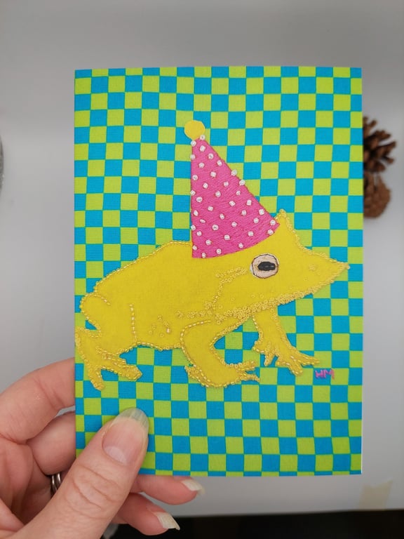 Birthday or celebration card of frog wearing a party hat - blank inside