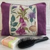 Purple toiletry bag with floral panel featuring wildflowers