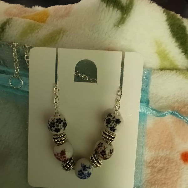 Lovely beaded bracelet with flower details painted on the beads, silver charms, 