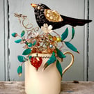 Blackbird sitting in his nest on a small vintage cup
