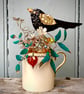 Blackbird sitting in his nest on a small vintage cup - Image 1