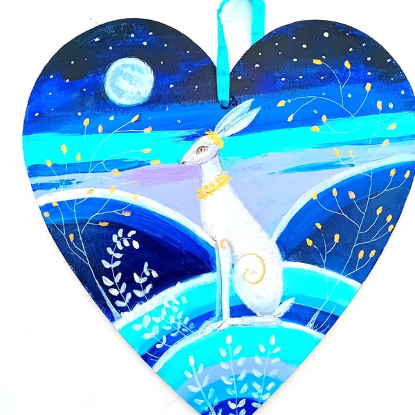White hare with golden collar on a heart shape 