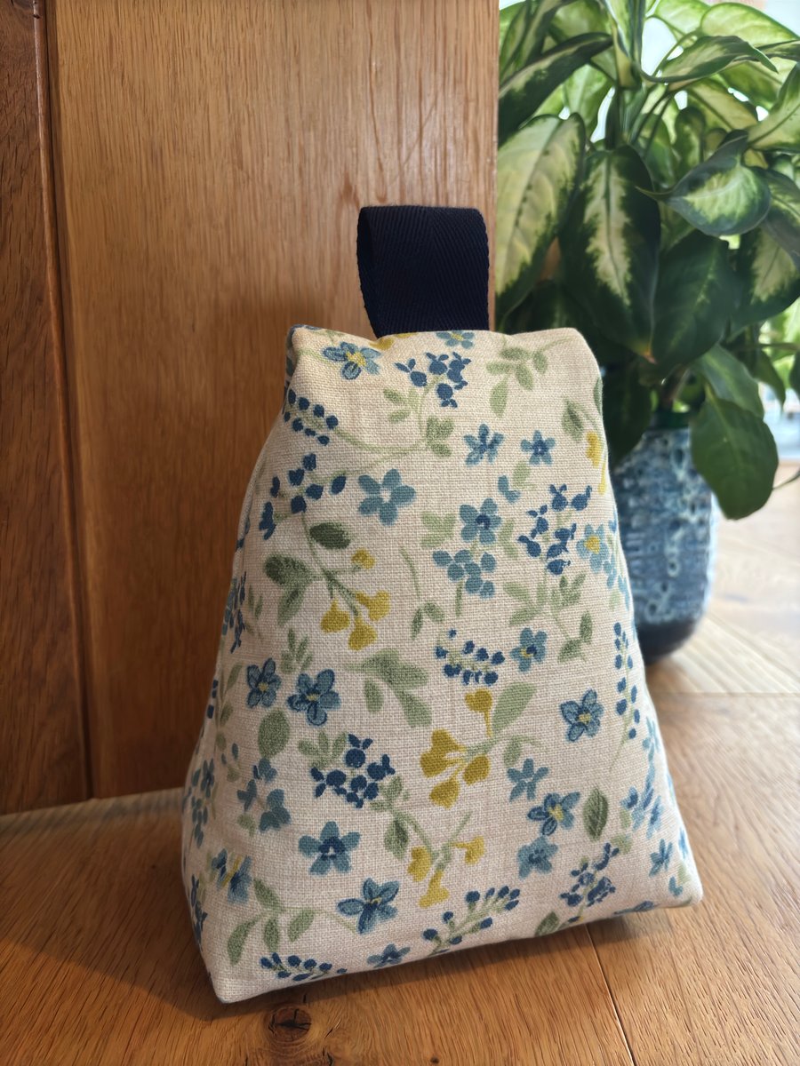 Cotton fabric doorstop in delicate floral print, filled with pebbles.