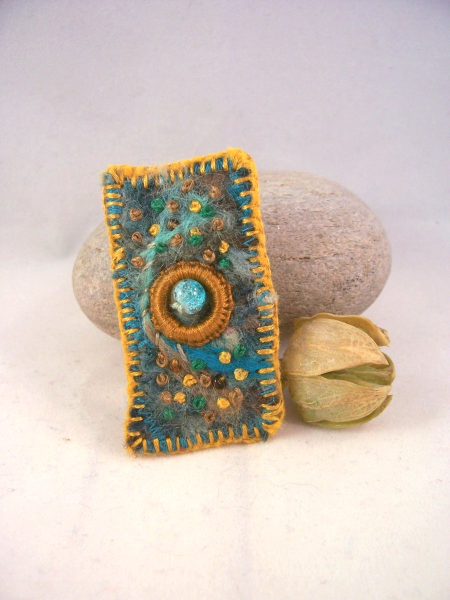Hand embroidered needlefelt brooch with mustard embroidery