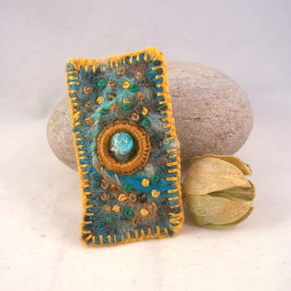 Hand embroidered needlefelt brooch with mustard embroidery