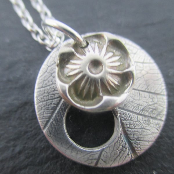 Silver flower and leaf disc pendant