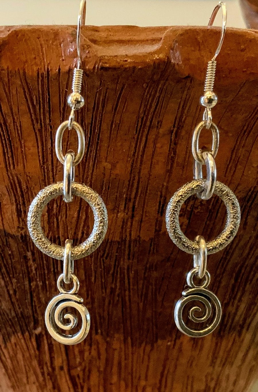 Metal frosted loop earrings with spiral charms