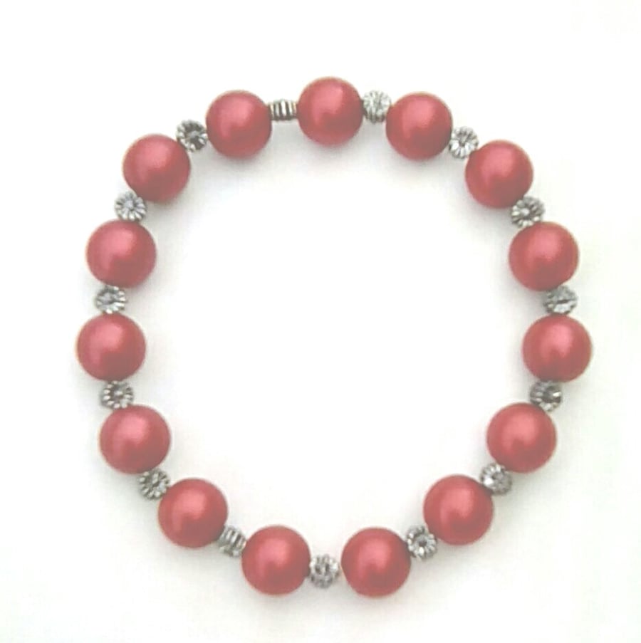 Stretchy bracelet with red glass pearls and silver plated spacers.