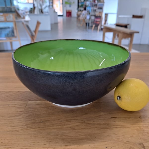 A LARGE HAND THROWN BOWL - glazed in vibrant green and charcoal