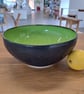 A LARGE HAND THROWN BOWL - glazed in vibrant green and charcoal