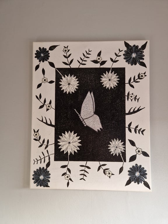 Black and white flowers and sequinned butterfly picture on canvas. 