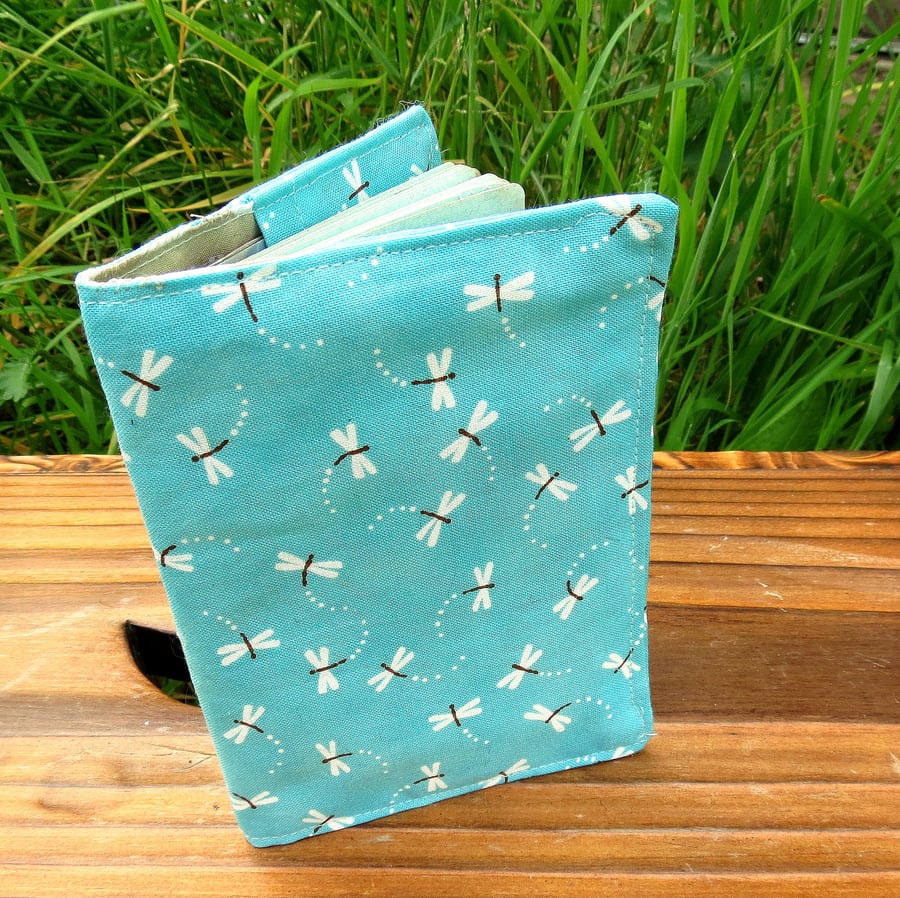 A fabric passport cover with a dragonfly design.