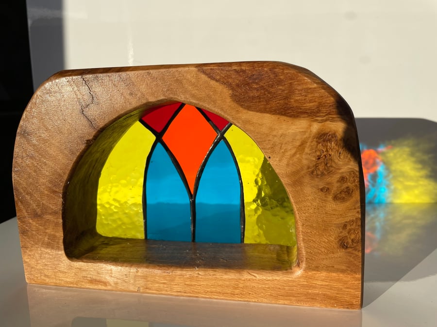 Stained glass semi-circular sun catcher framed by a sold oak surround 