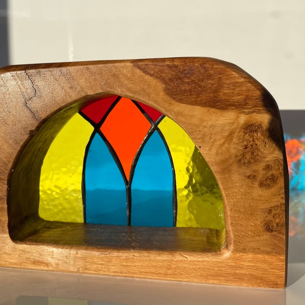 Stained glass semi-circular sun catcher framed by a sold oak surround 