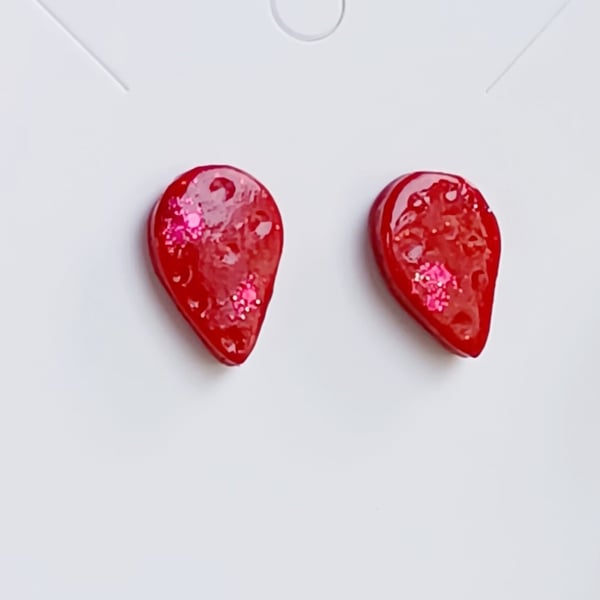 Teardrop shaped stud earrings with red sparkle
