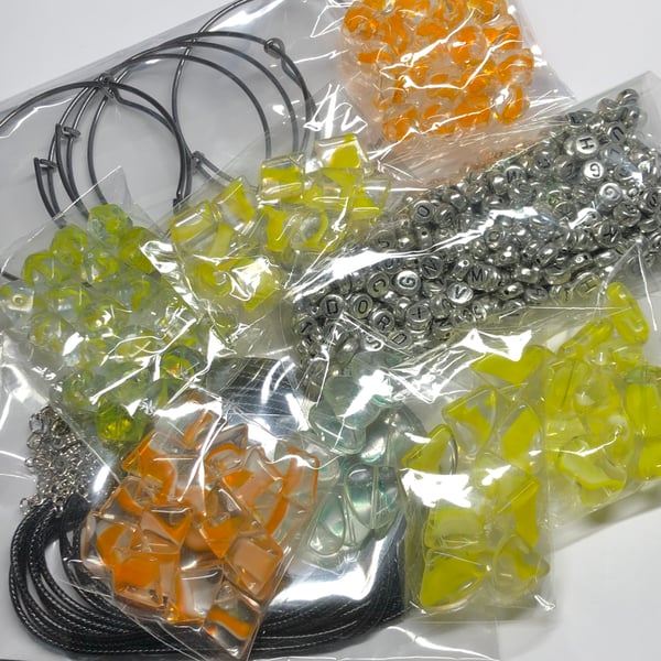 Ten yellow orange packs beads and jewellery making items